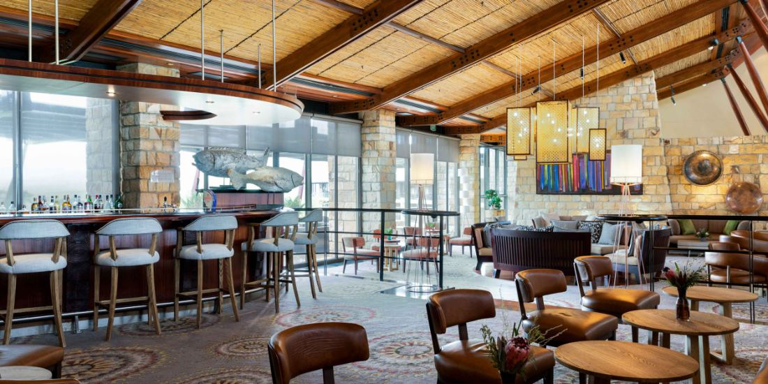 A bar and lounge with leather chairs and wooden beams