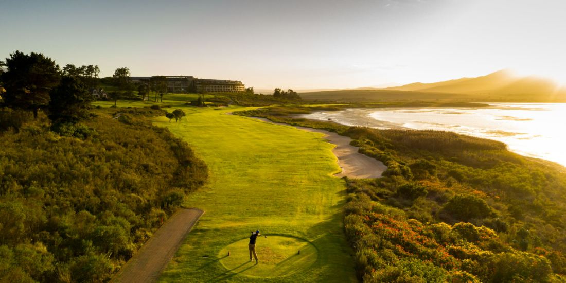 Golden evening light across a fairway and the lagoon beyond