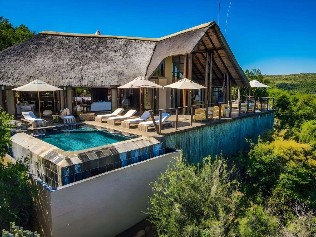 The main lodge, its pool and deck above the bush