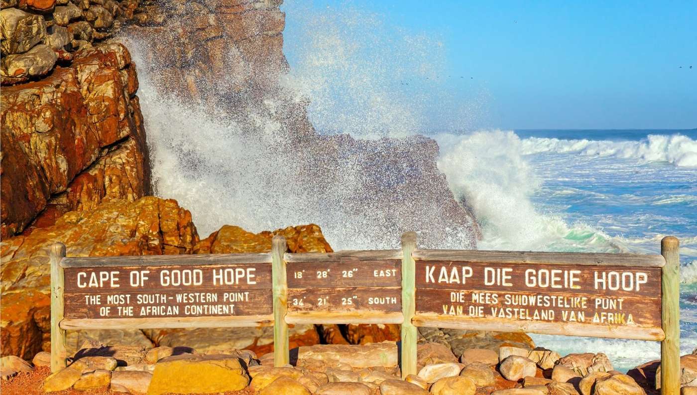 The Cape of Good Hope sign, with a wave breaking on the rocks behind