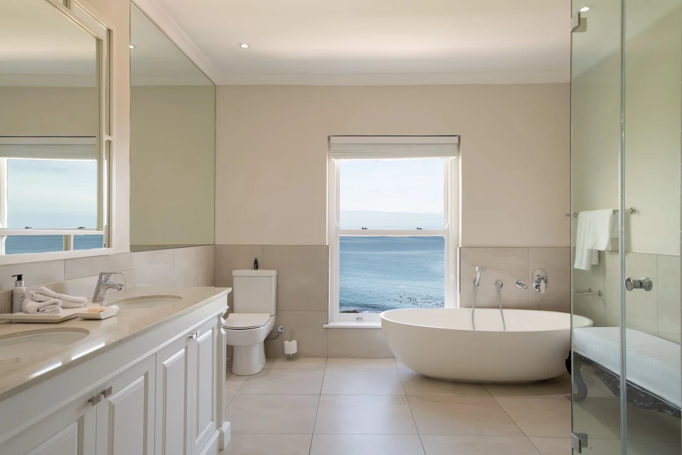A free-standing bath beneath a window looking straight out to sea
