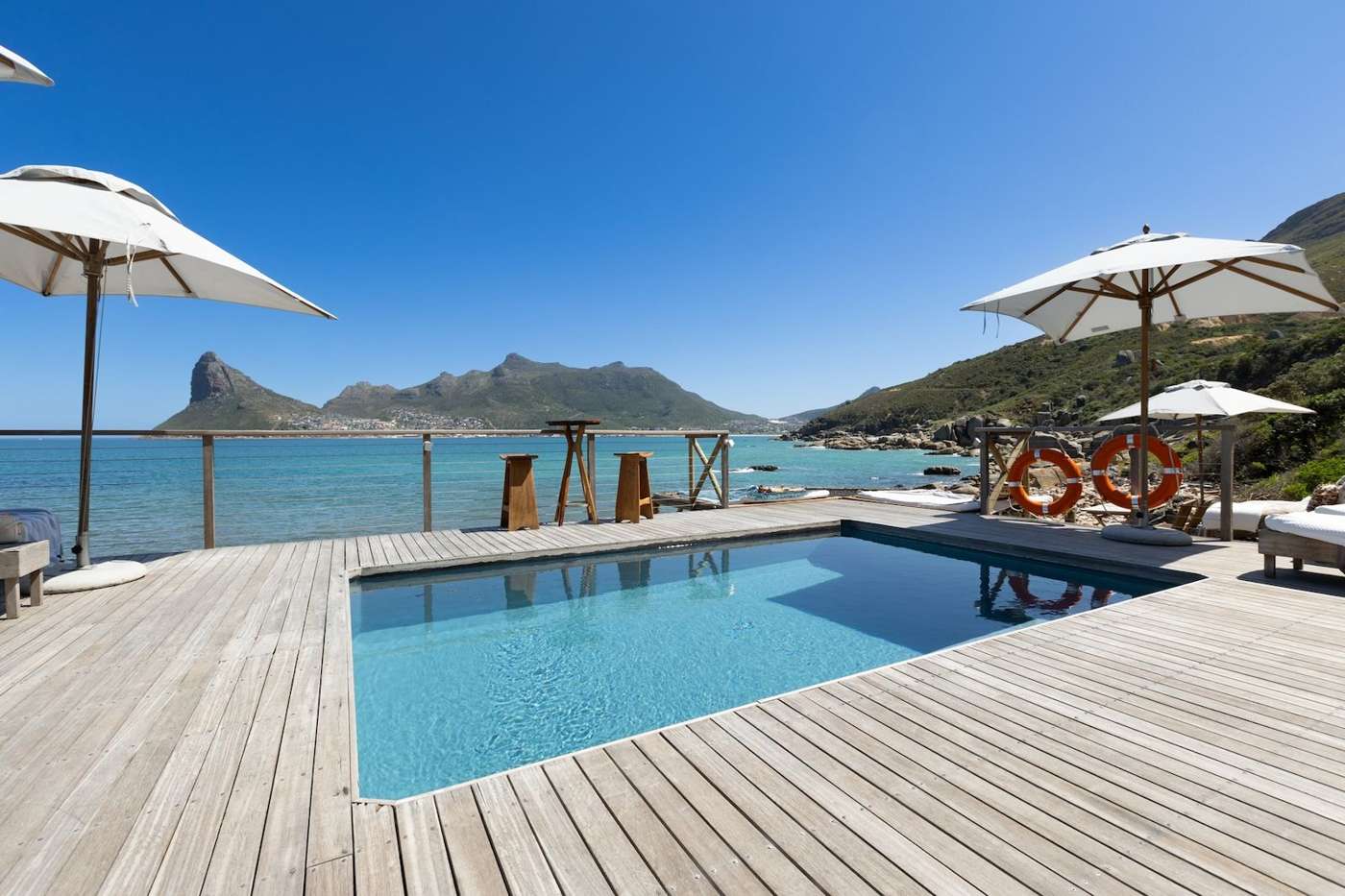 The pool deck at Tintswalo Atlantic, looking across Hout Bay to the Sentinel