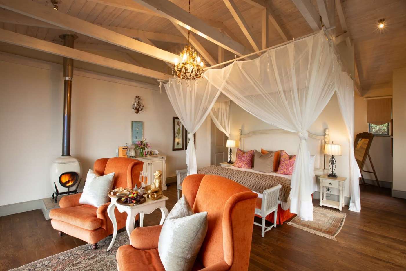 A Luxury Island Suite with a canopied bed and armchairs