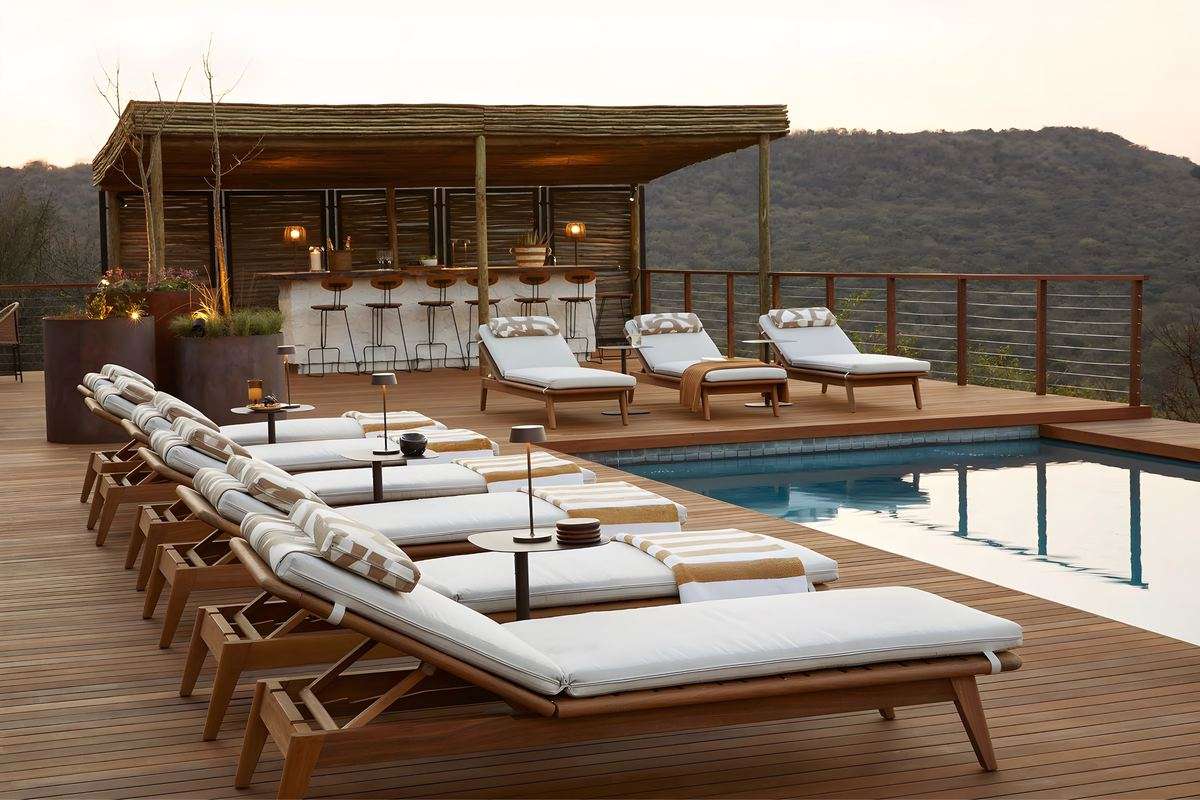 Loungers beside the pool, with the bar under its thatch behind