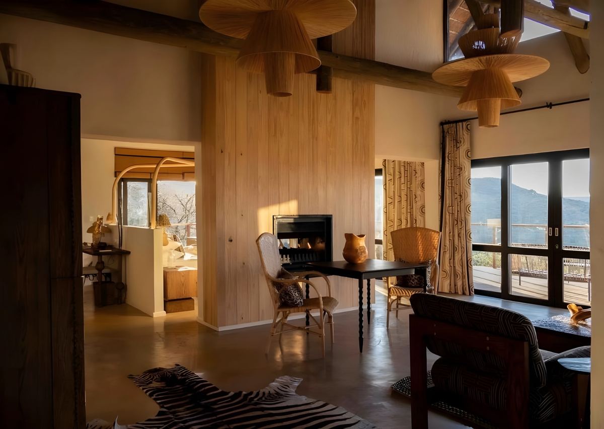 The sitting room of a suite, with a fireplace and views to the hills