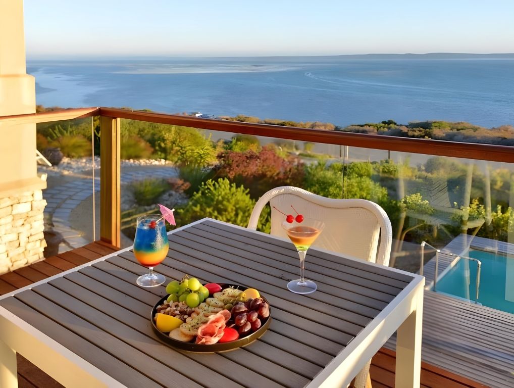 Cocktails and a platter on a balcony above the lagoon
