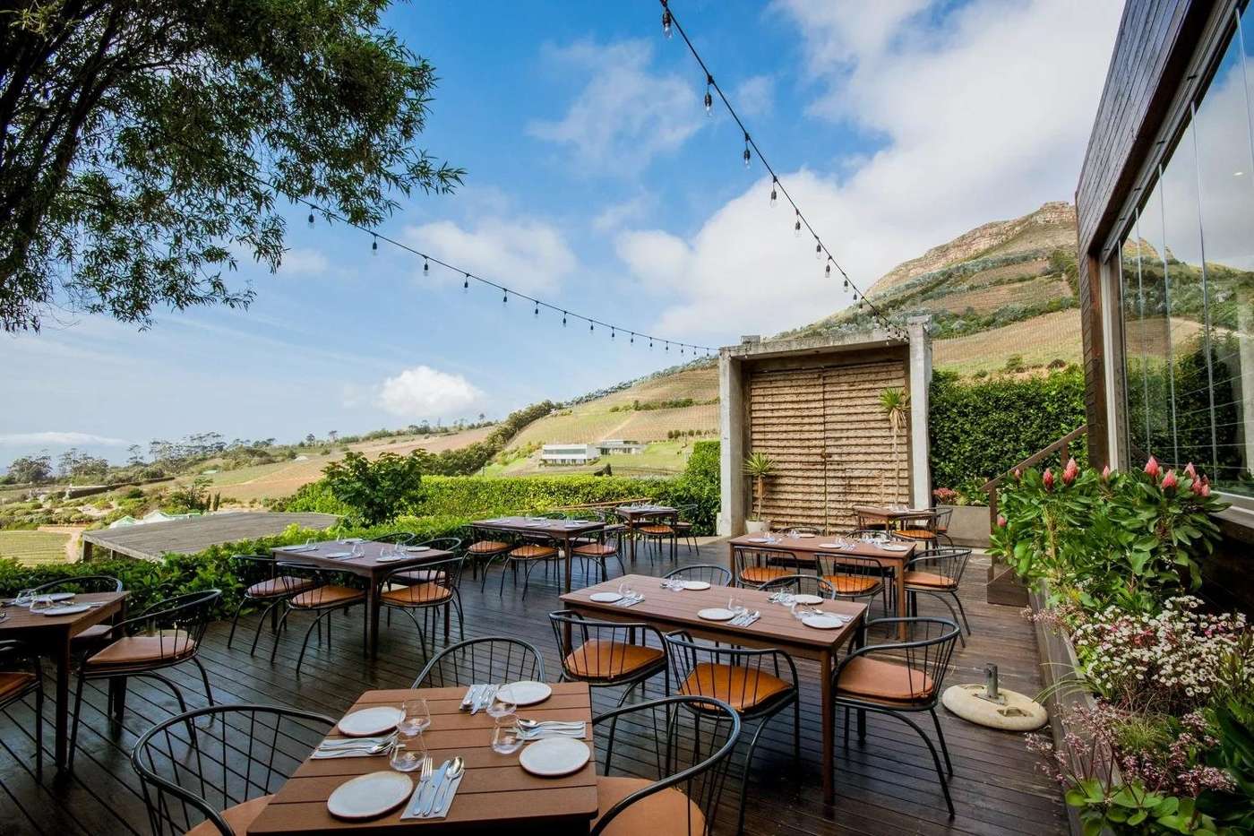 The restaurant terrace at Beau Constantia, with tables looking out over the valley and the mountains