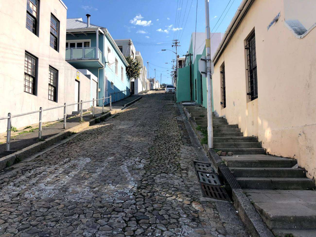 A steep cobbled street with steps between old houses