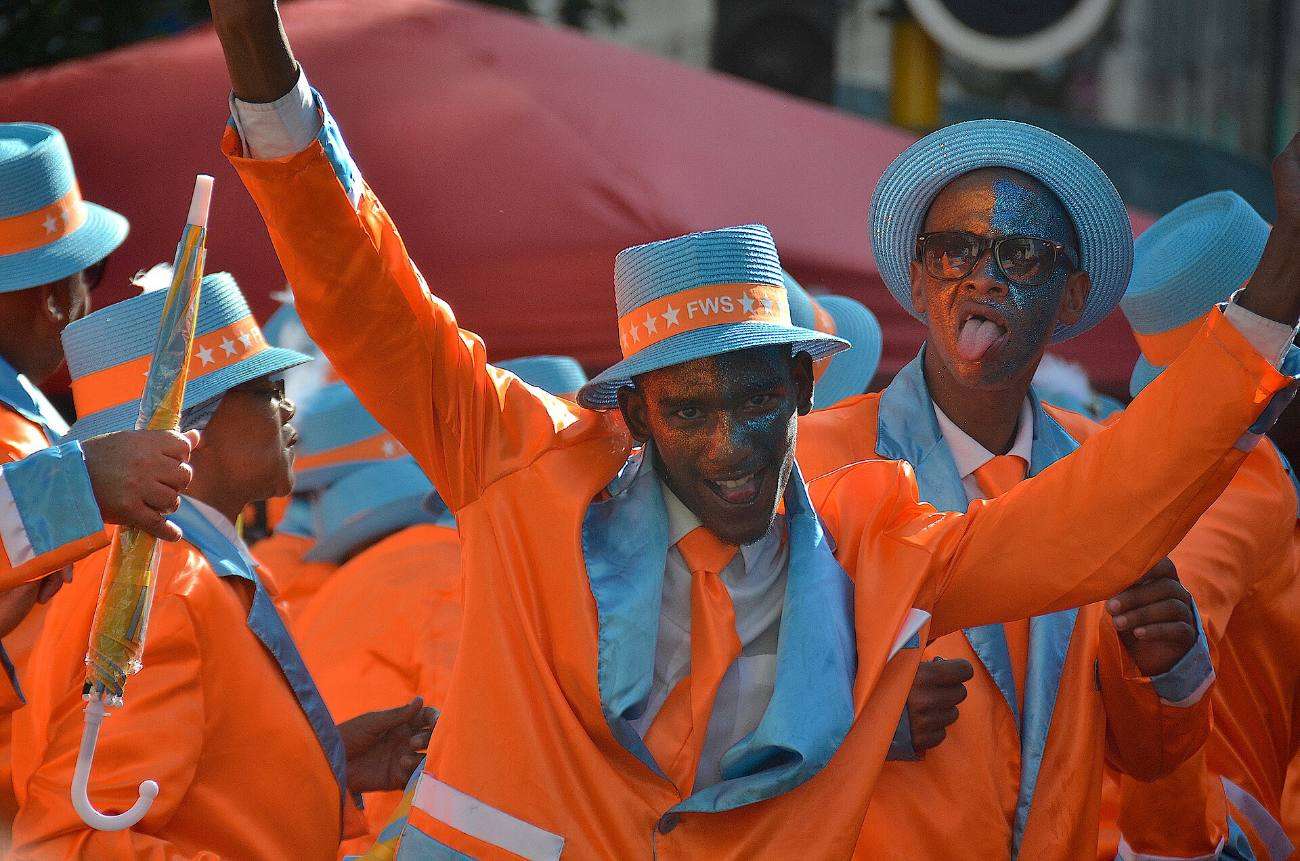 Minstrels in orange and blue satin suits and hats dancing in a Cape Town street