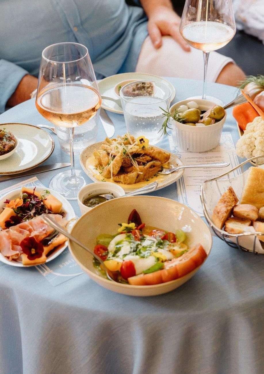 Shared plates and wine on a table at Café Caprice