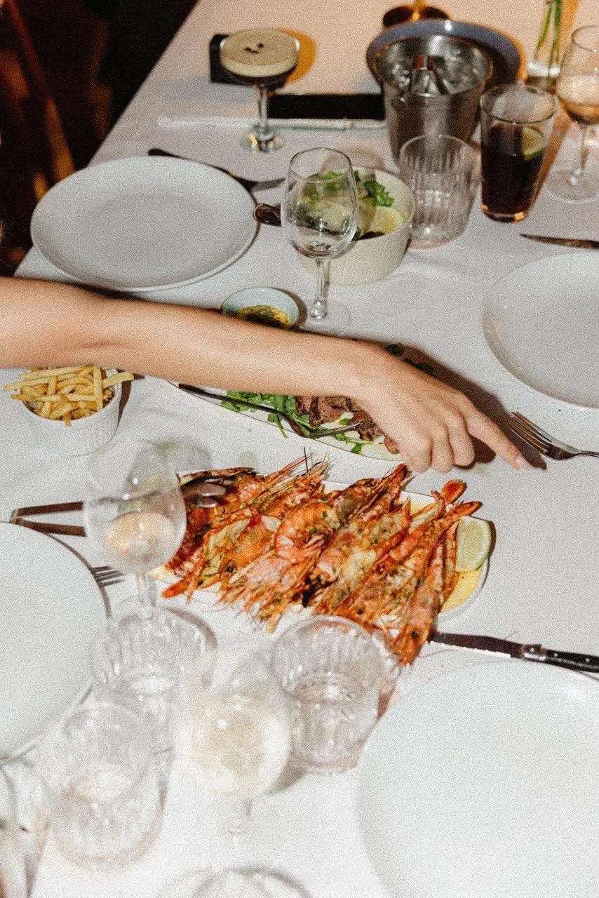 A plate of grilled prawns on a white tablecloth