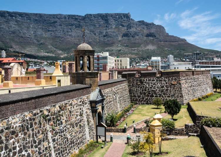 The stone walls and bell tower of the Castle of Good Hope with Table Mountain behind