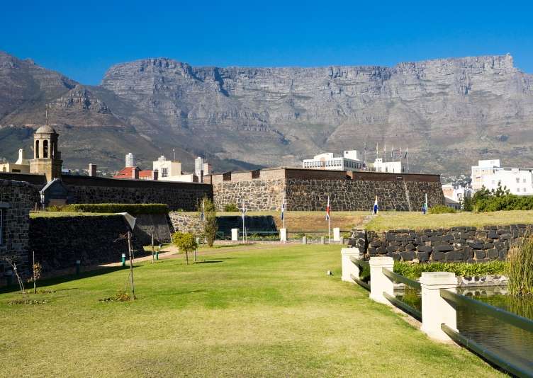 The lawns and moat outside the Castle walls with Table Mountain beyond