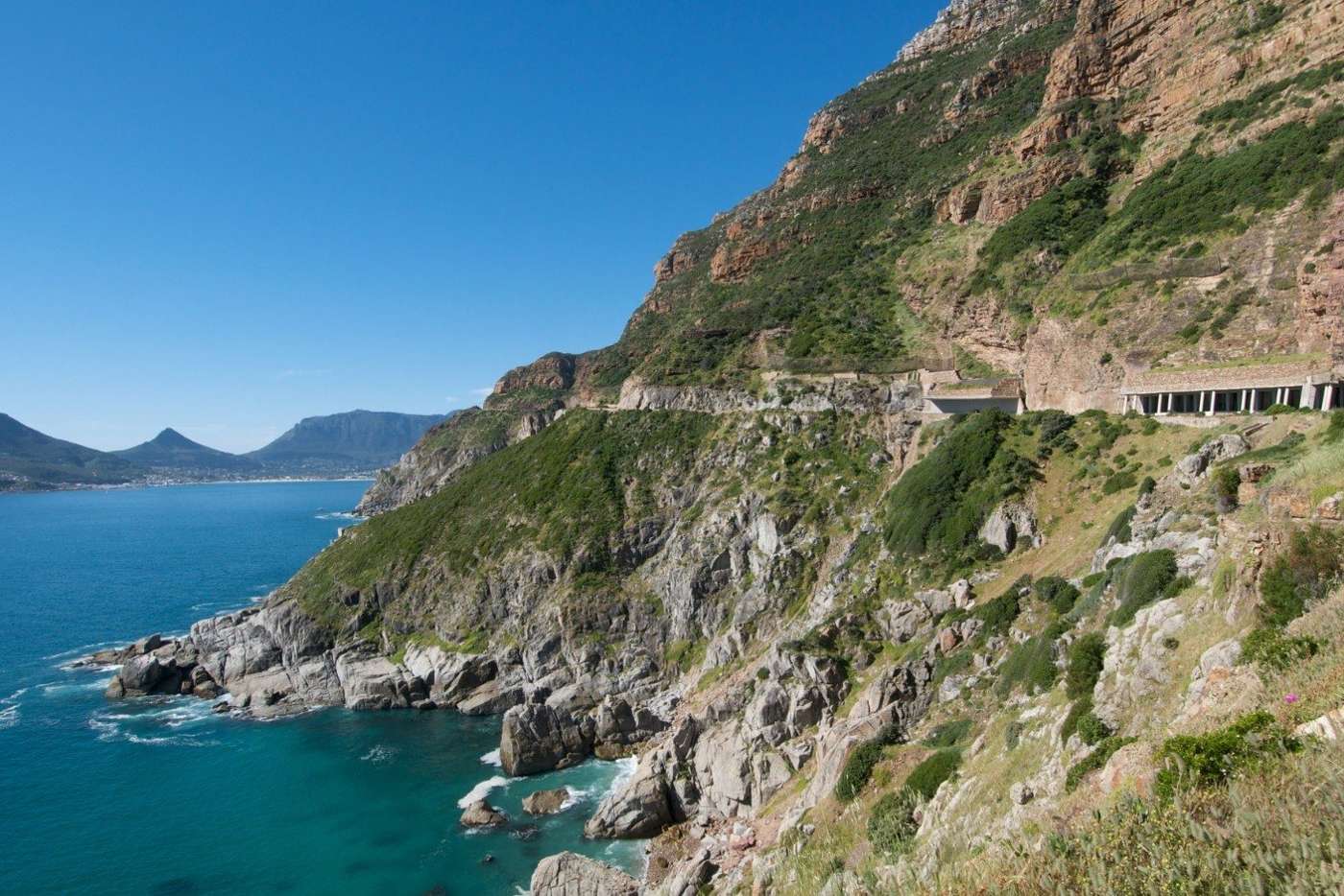 The road and its covered gallery cut into the cliff above the sea