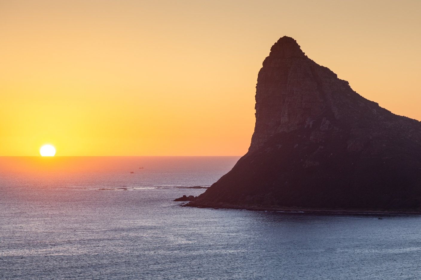 The sun setting into the Atlantic beside the Sentinel