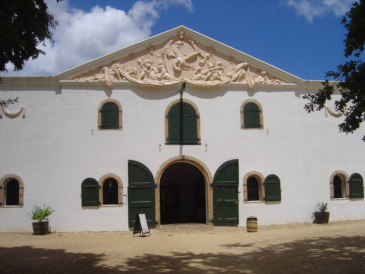 The white Cloete Cellar with its carved pediment and green doors