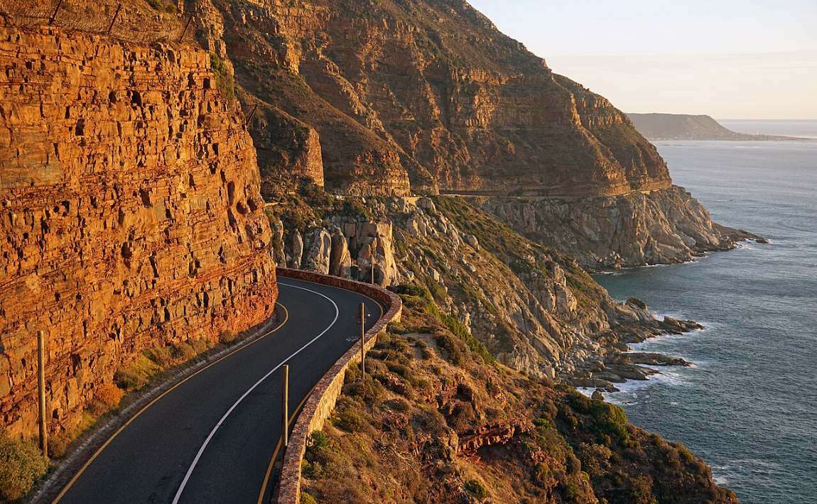 Chapman&rsquo;s Peak Drive cut into orange cliffs high above the sea