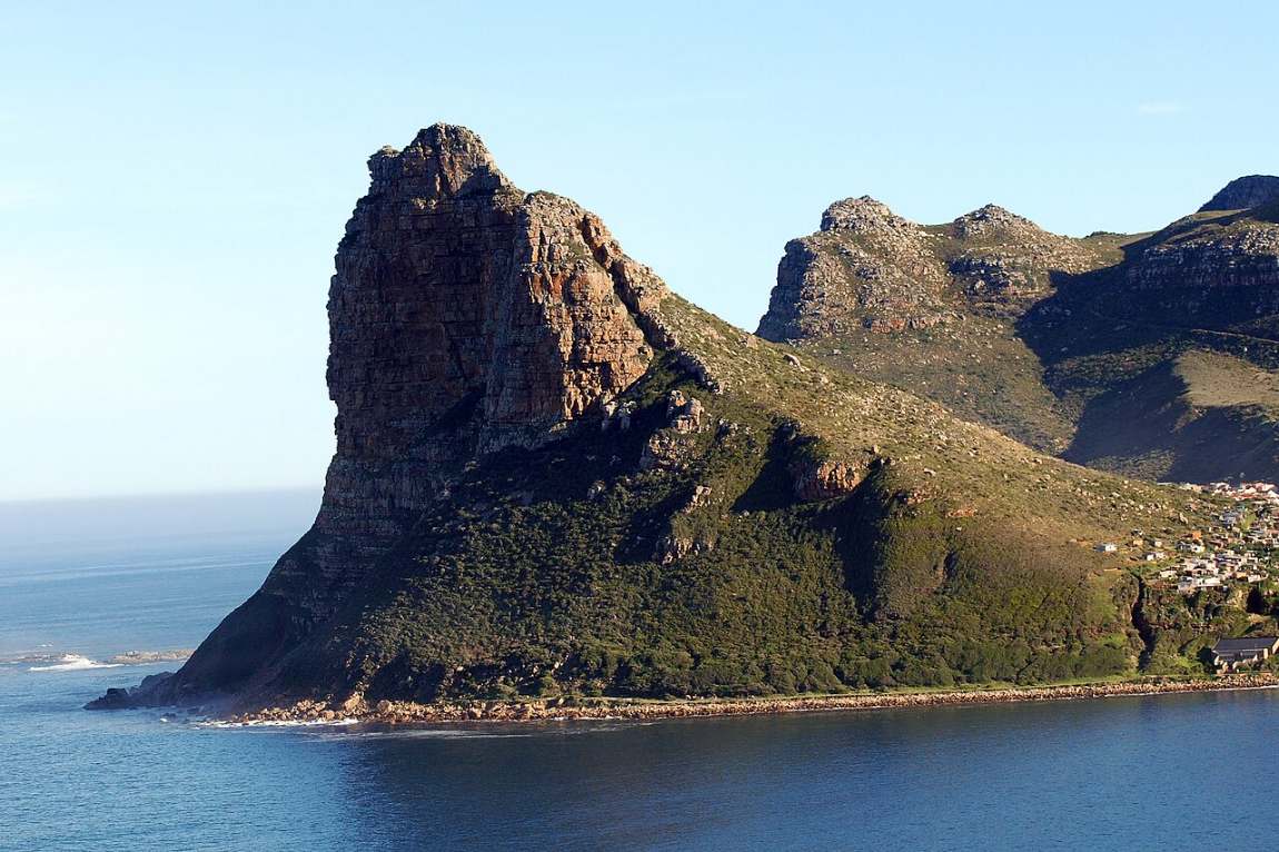The steep rock of the Sentinel rising out of the sea at the mouth of Hout Bay