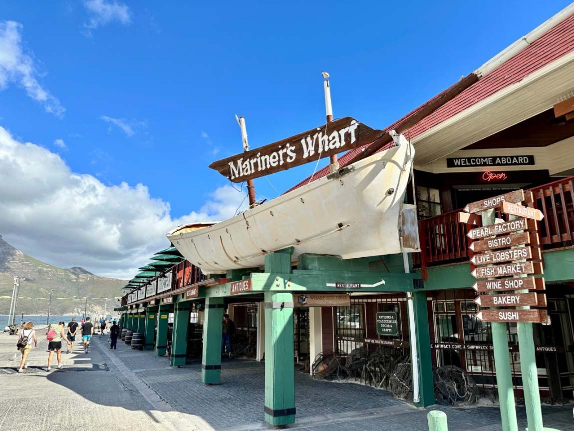 The timber facade and boat sign of Mariner&rsquo;s Wharf on the harbour front