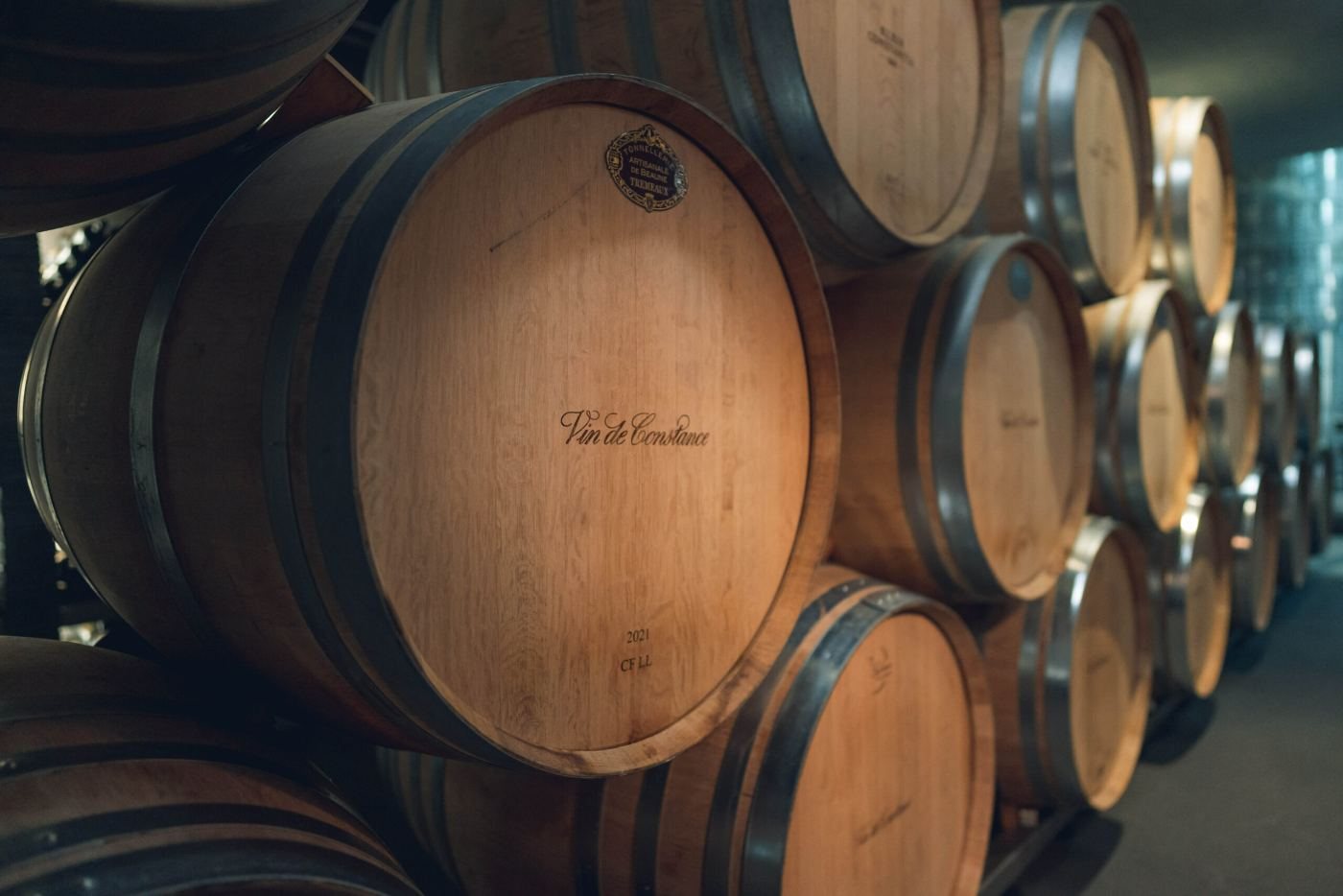 Rows of oak barrels marked Vin de Constance in the cellar