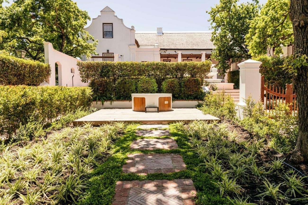 A garden path leading to the white-gabled Manor House