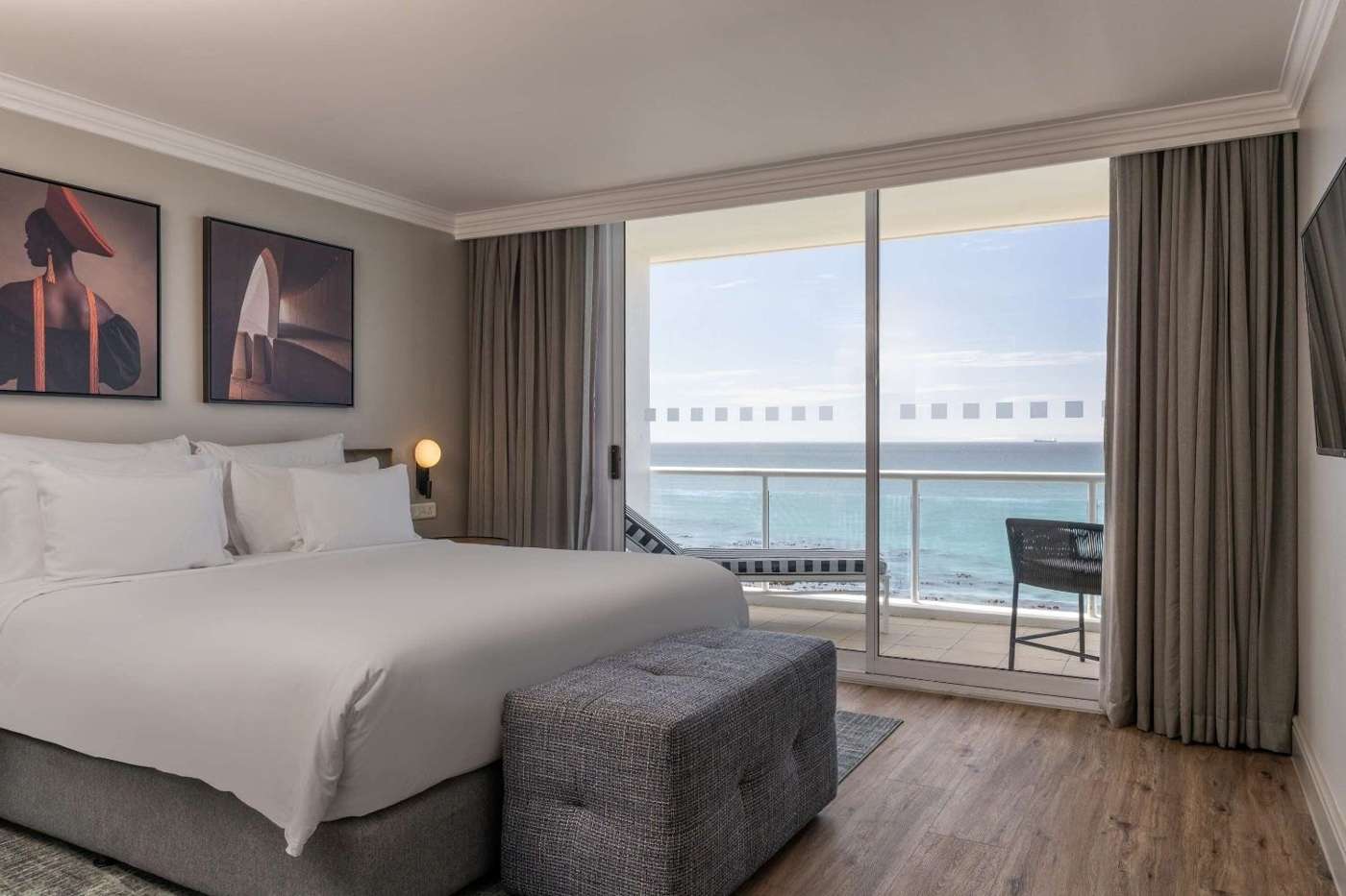 A bedroom with a balcony looking straight over the ocean