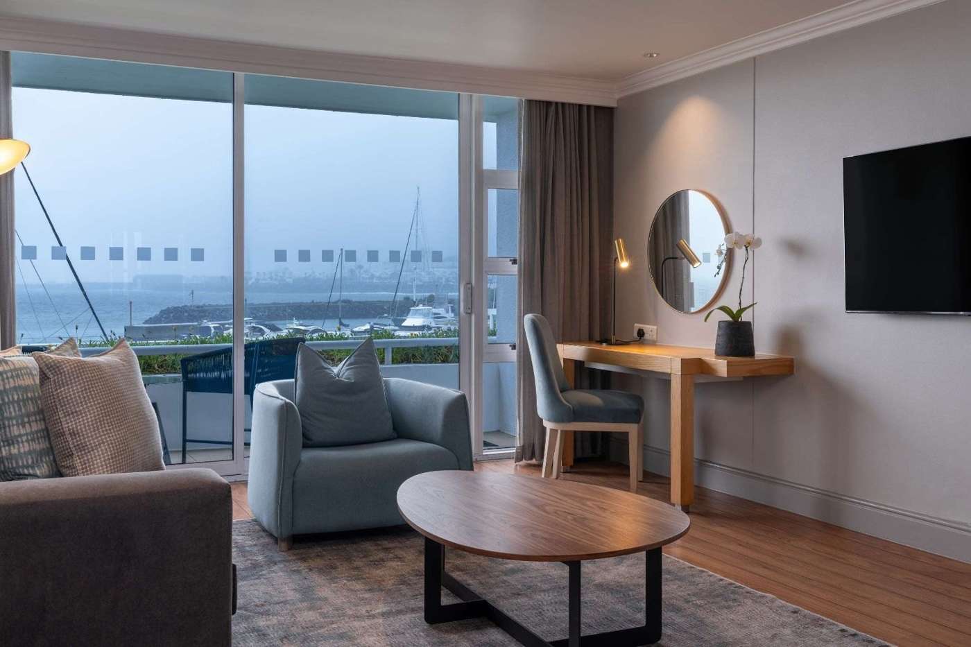 A suite lounge with sofas and a balcony over the sea
