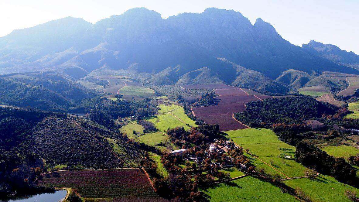 Rustenberg from the air, with vineyards and green fields below the Simonsberg