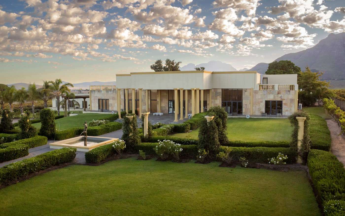 The Stellenrust building and its formal gardens from above, with mountains on the horizon