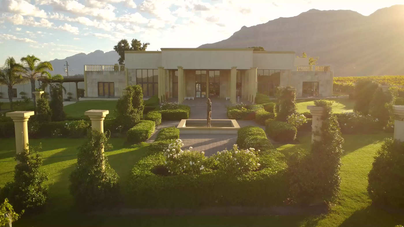 The Stellenrust building in the evening light, with formal gardens in front and the mountains behind