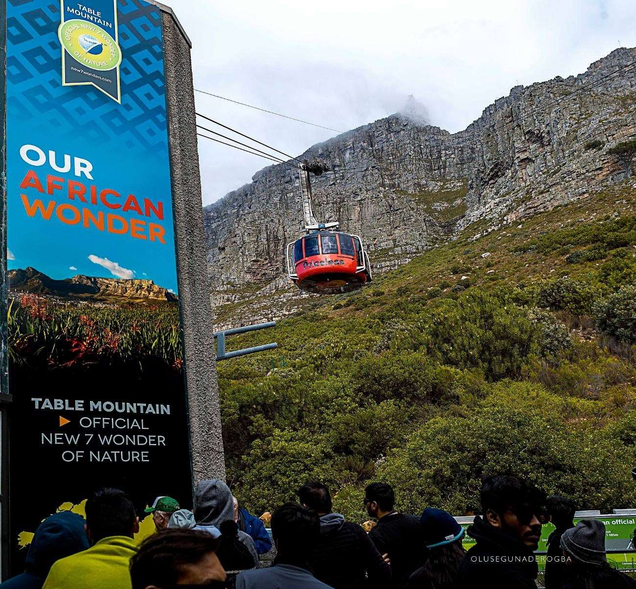 A red cable car climbing towards the summit